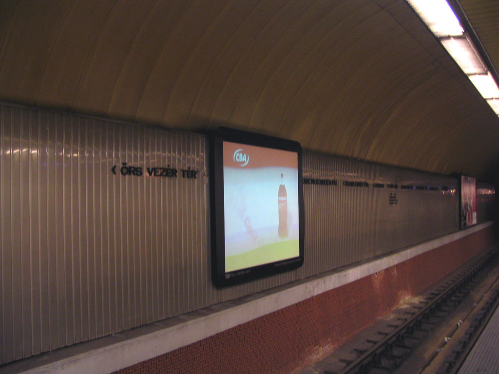 St�na stanice D�li p�lyaudvar s projek�n�m pl�tnem a reklamn�m panelem